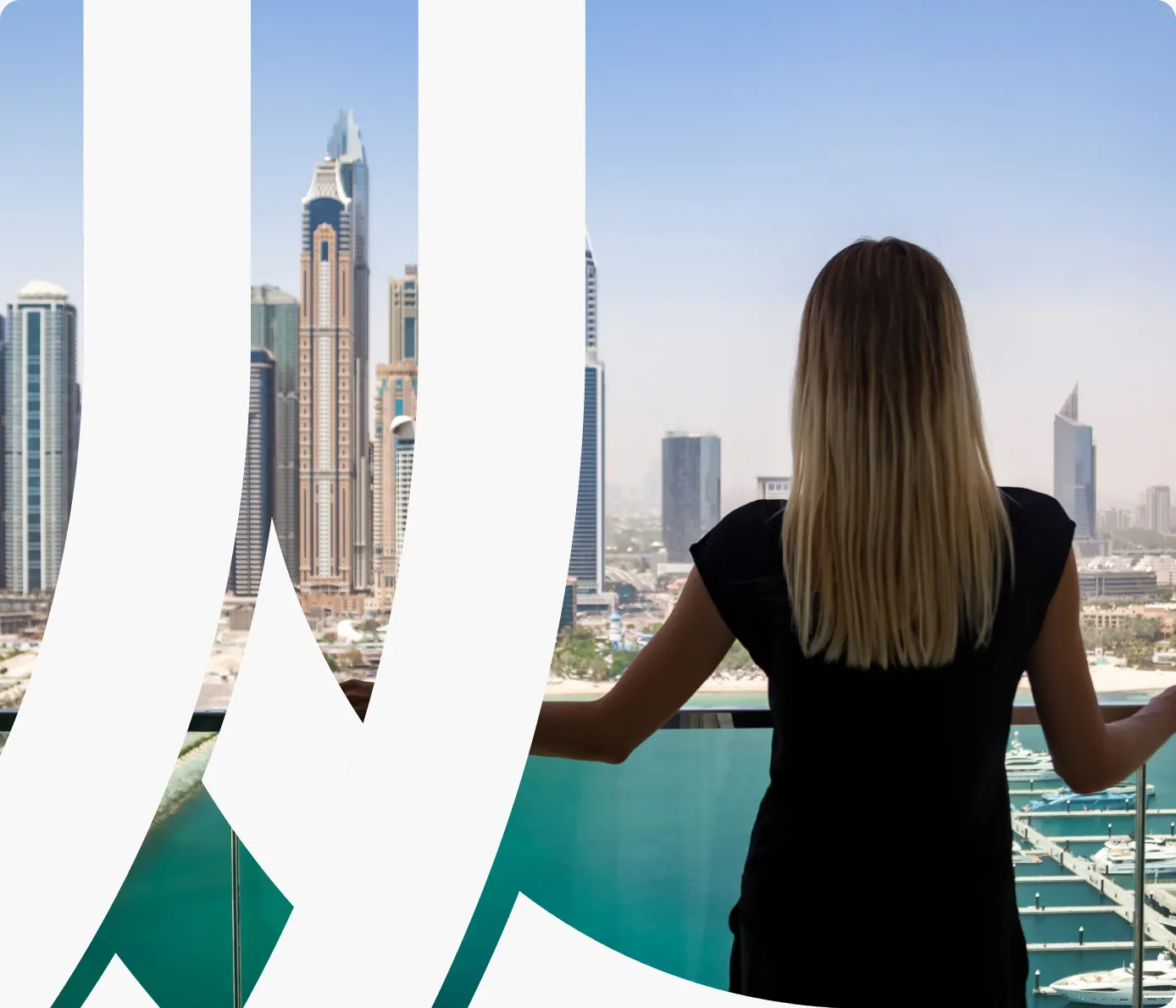 A woman on a balcony overlooking a pool and the Dubai Marina towers