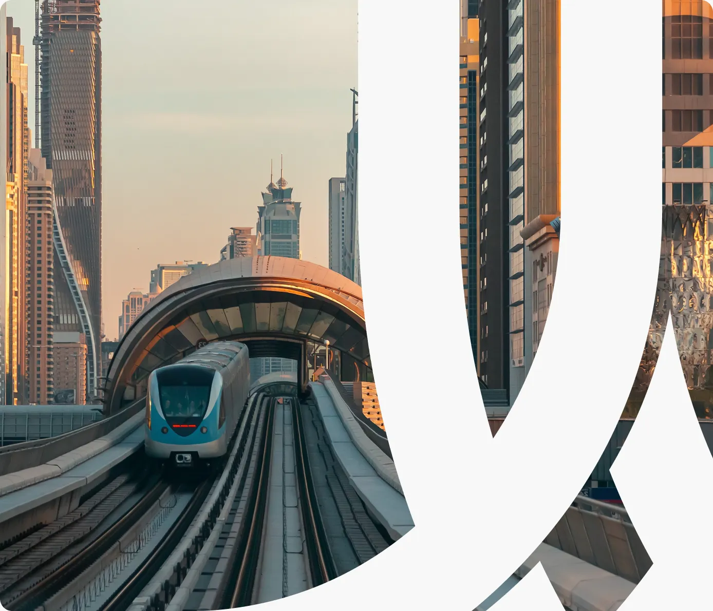 A Dubai Metro train arriving on an elevated track between skyscrapers